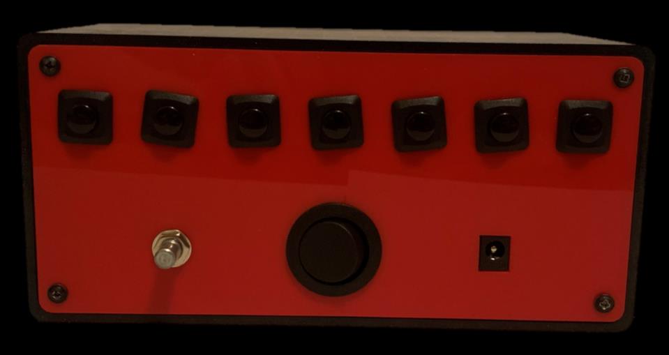 Rear face of the clock, showing the seven buttons, volume dial, power switch, and DC input