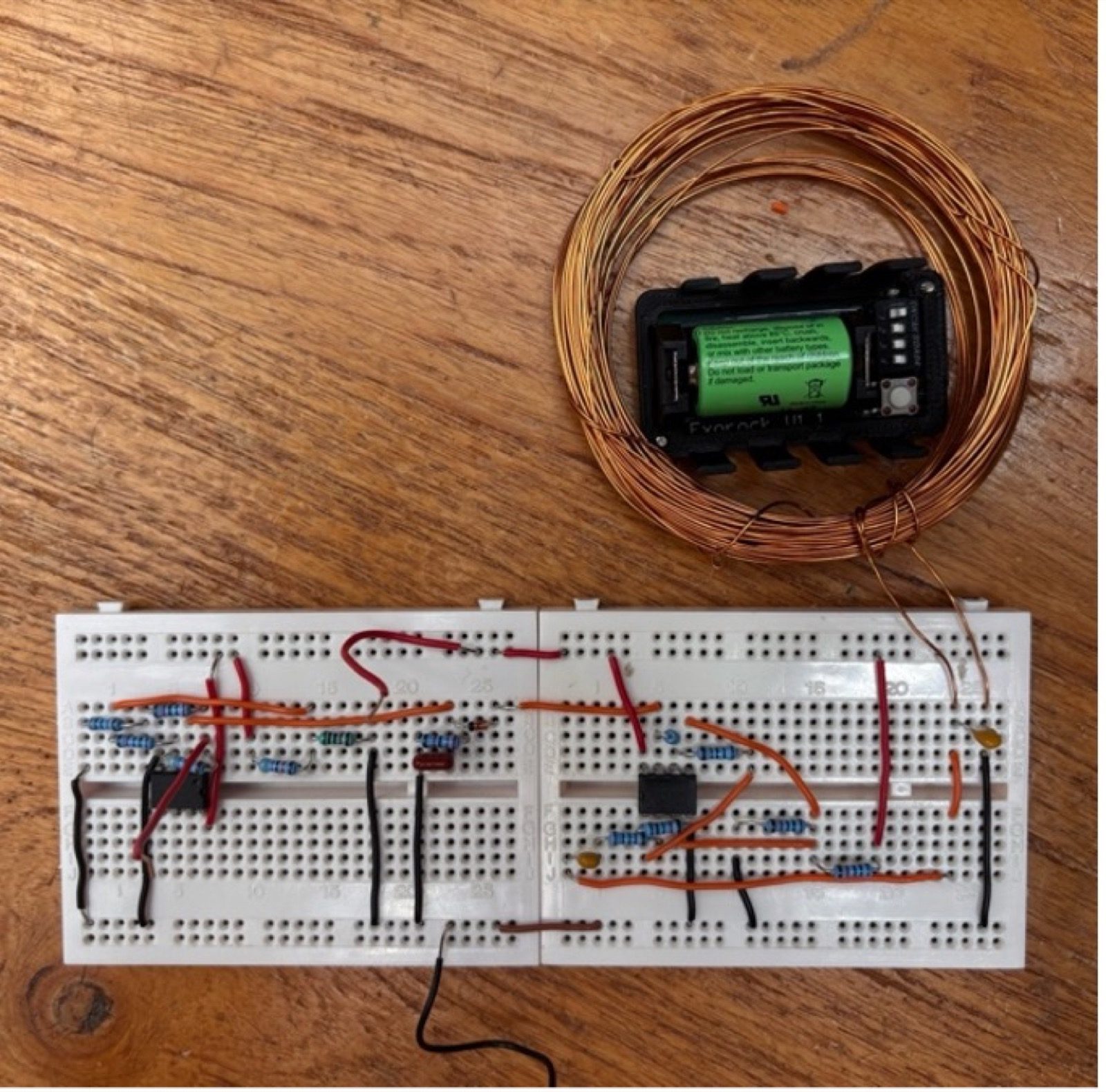 RF transmitter prototyped on breadboard for testing, wired to a hand-wound coil and the rock’s own battery/switch/button assembly